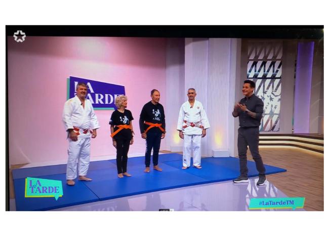 Dos alumnos que participan en el proyecto de judo para mayores junto a los entrenadores, Enrique Eraña y Antonio Núñez, y al presentador del programa de Telemadrid, La Tarde, Christian Gálvez
